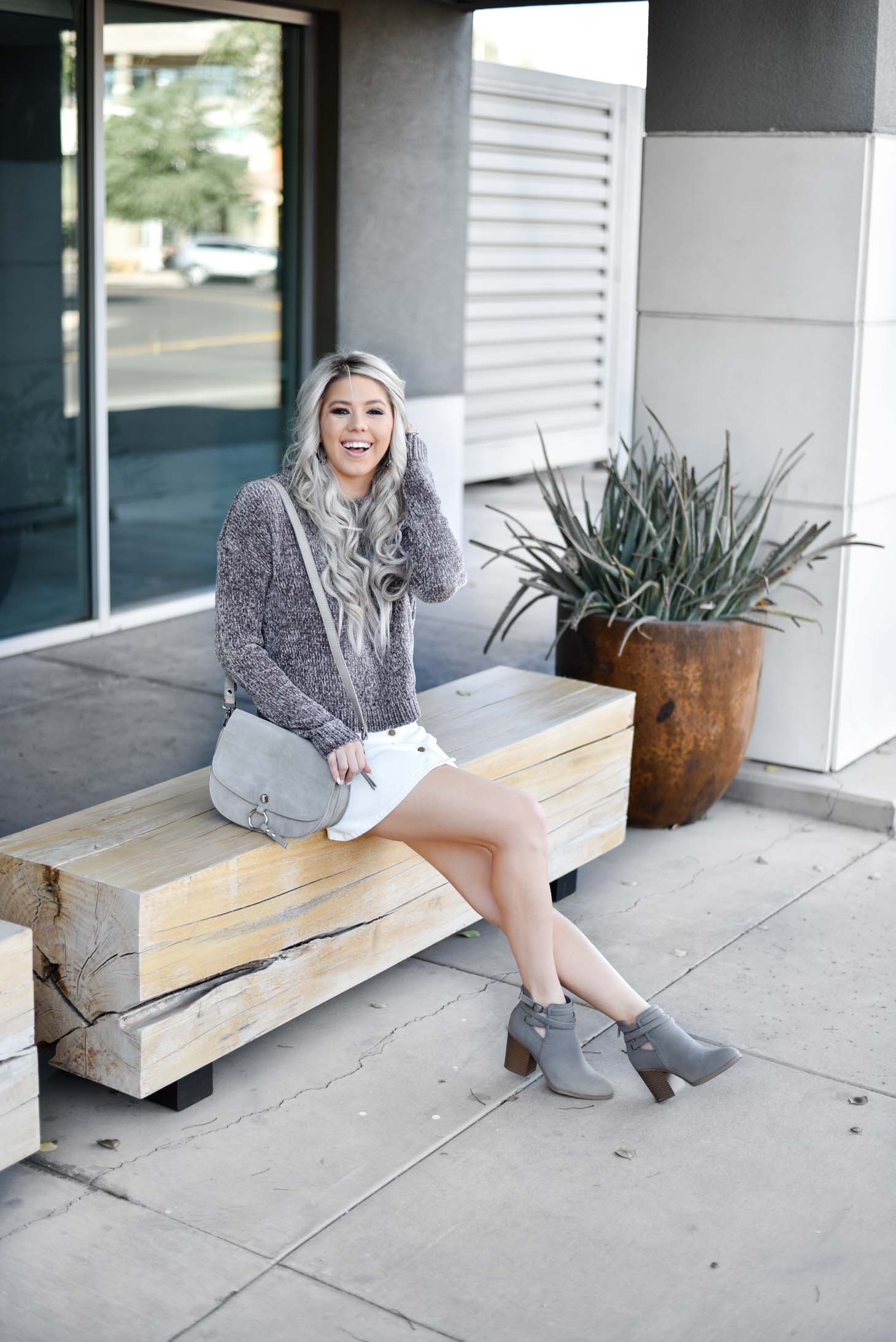 Erin Elizabeth of Wink and a Twirl shares a fall look from Red Dress Boutique with a cute hooded sweater and white miniskirt 