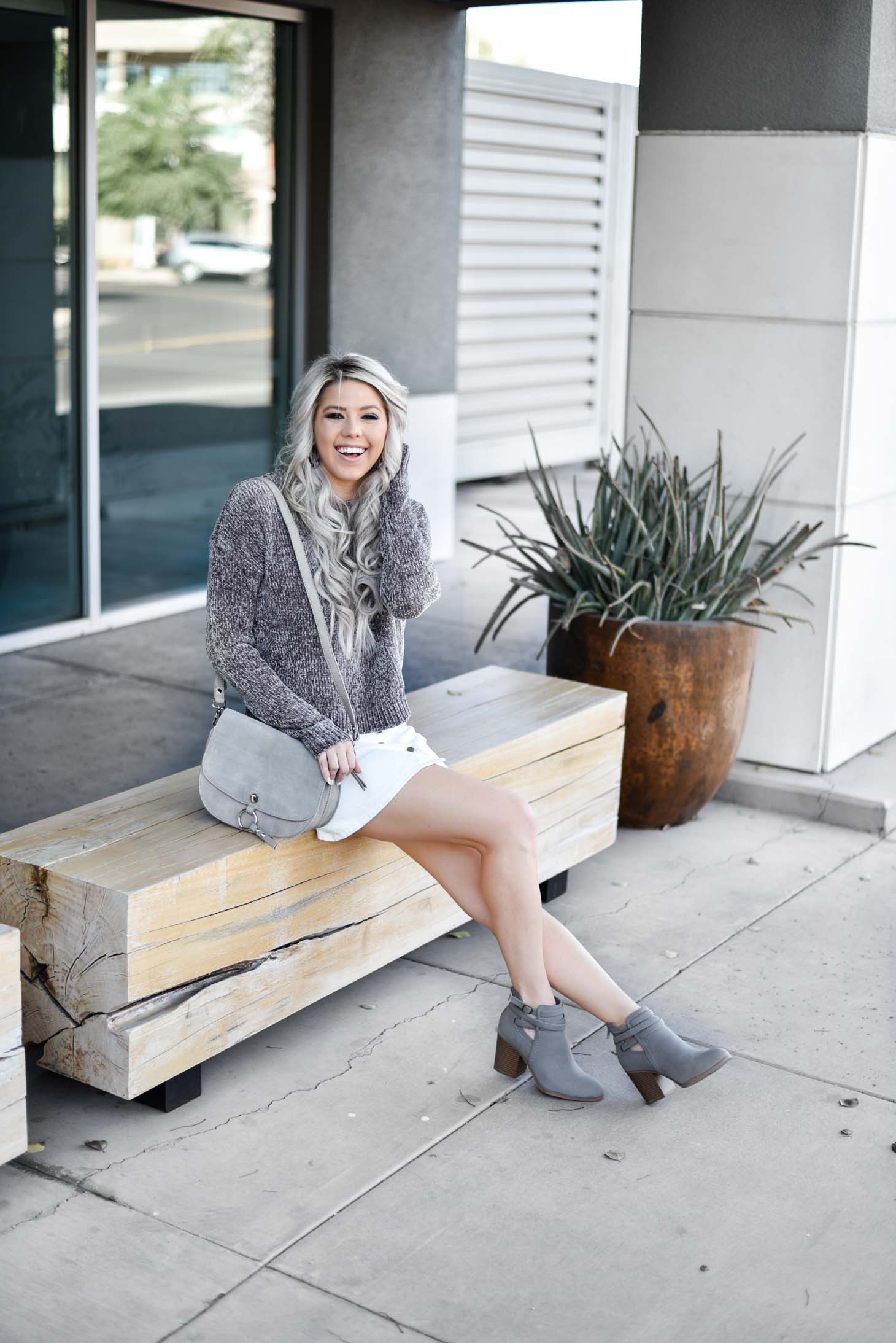 Erin Elizabeth of Wink and a Twirl shares a fall look from Red Dress Boutique with a cute hooded sweater and white miniskirt 