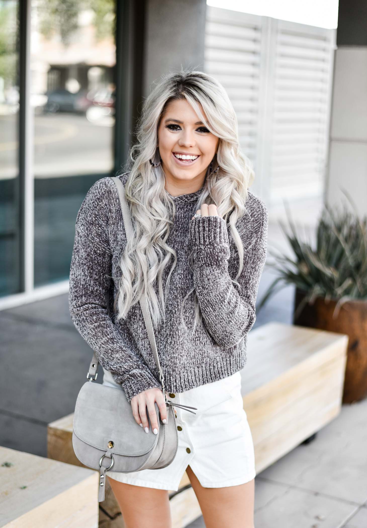 Erin Elizabeth of Wink and a Twirl shares a fall look from Red Dress Boutique with a cute hooded sweater and white miniskirt 