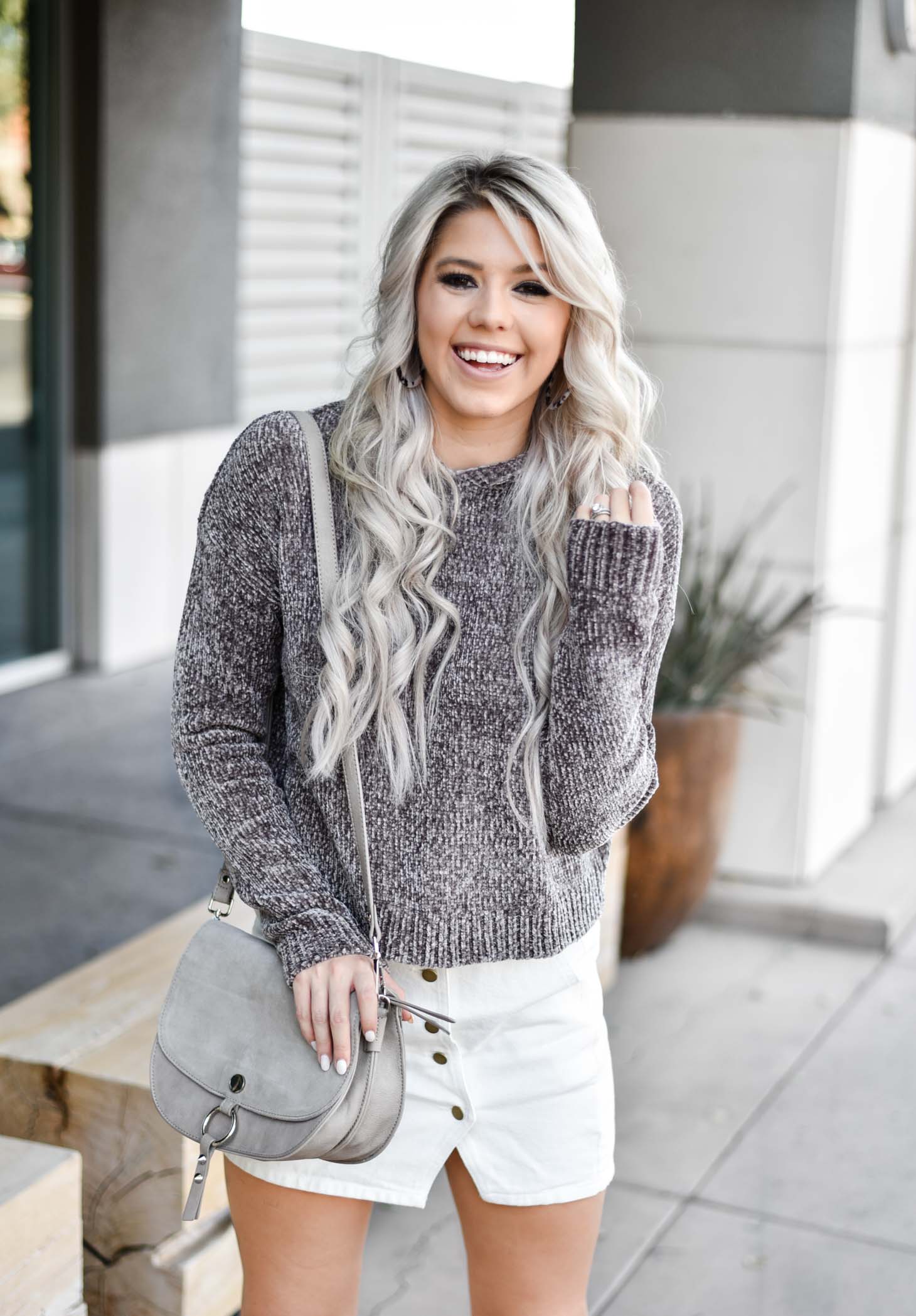 Erin Elizabeth of Wink and a Twirl shares a fall look from Red Dress Boutique with a cute hooded sweater and white miniskirt 